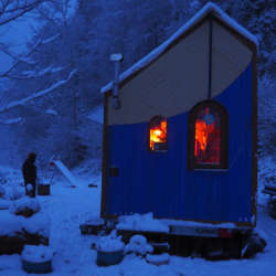 Tiny House im Schnee bei Abenddämmerung
